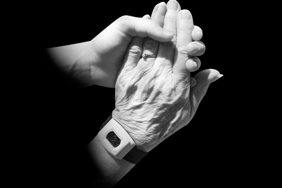 Immagine di due mani, una giovane che sostiene quella di una persona anziana